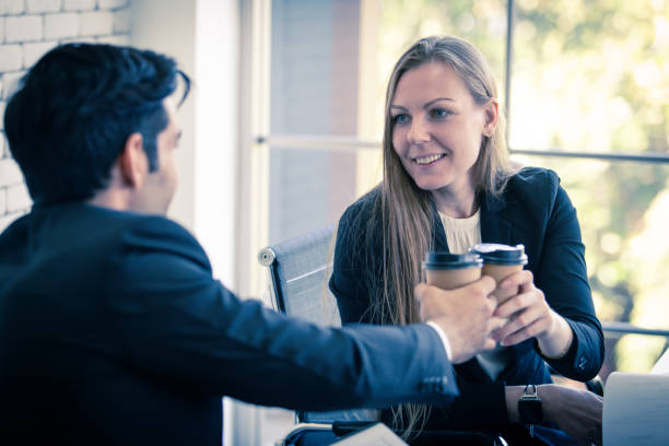 istock Female office workers chat friendly with male employees ready to drink coffee during afternoon work hours. 1329350555