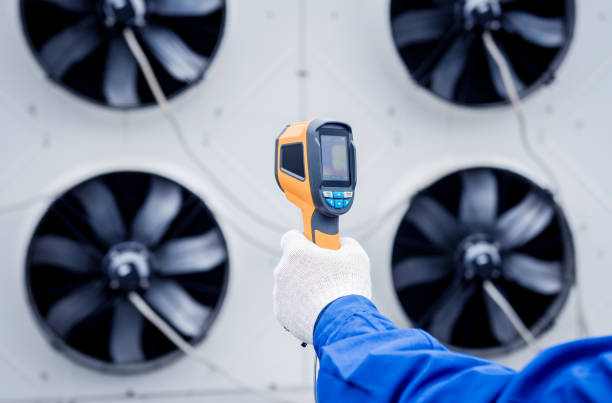 istock Technician uses a thermal imaging infrared thermometer to check the condensing unit heat exchanger. 1329351579