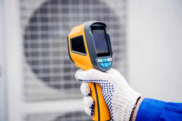 istock Technician uses a thermal imaging infrared thermometer to check the condensing unit heat exchanger. 1329352283