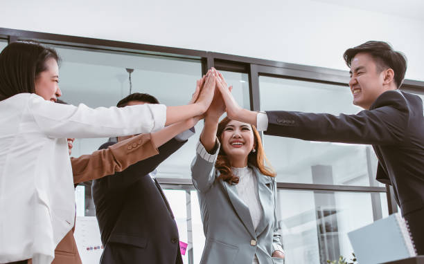 istock Group of Asian teamwork businesspeople making high five with togetherness or tag their hands with happiness and confidence after getting success on their projects and goal achievement. 1329352985