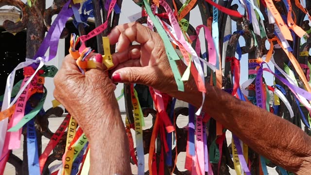 Female hands tying up a ribbon on Our Lord of Bonfim church in Salvador, Bahia