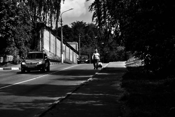 Photo of shadow of boy and mother pushing baby troller in sunset. Focus on shadows. Shot in outdoor during sunset. backlit effect is used.