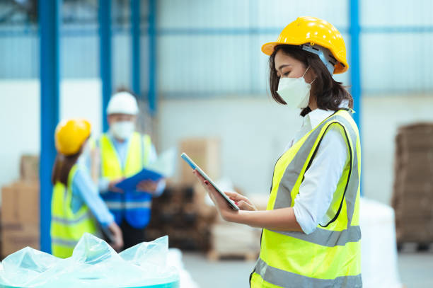 istock Chief industrial engineer inspects the factory Discussing a new project while using a laptop. They show a determined gesture. There are employees working diligently in the back. 1329357748