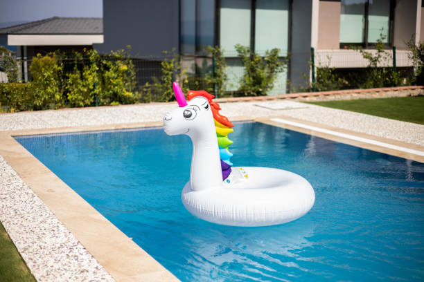 надувной разноцветный белый единорог у бассейна - swimming pool toy inflatable ring float стоковые фото и изображения
