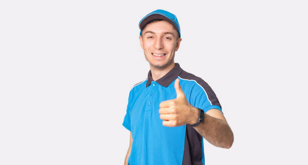 istock The courier man in work uniform holding his thumb up means he is happy for working as a delivery man. 1329359336