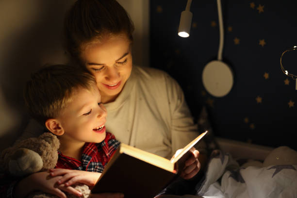istock Cheerful mother and son cuddling and reading book 1329360076