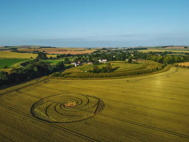 The village of Avebury in Wiltshire. No one knows the creator of the crop circle so could be man, woman or alien. Farmer is allowing access to the crop circle till harvest.