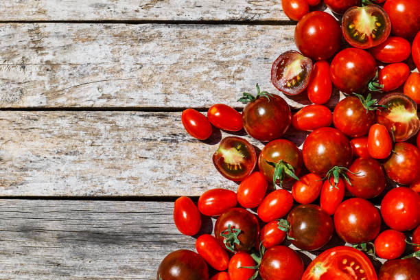 istock Red ripe tomatoes texture background. Different qualities of tomatoes on the wooden table. Black tomato Solanum lycopersicum. 1329364048