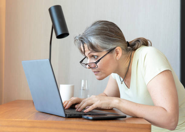 istock middle aged woman with bad eye sight working at home 1329365332