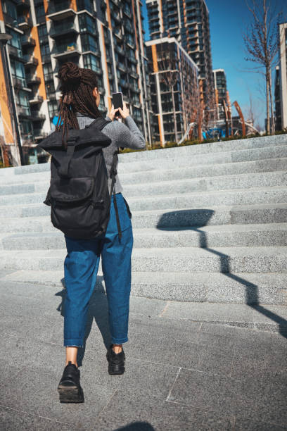 istock Lady with cornrows taking digital photos of a new residential district 1329366064