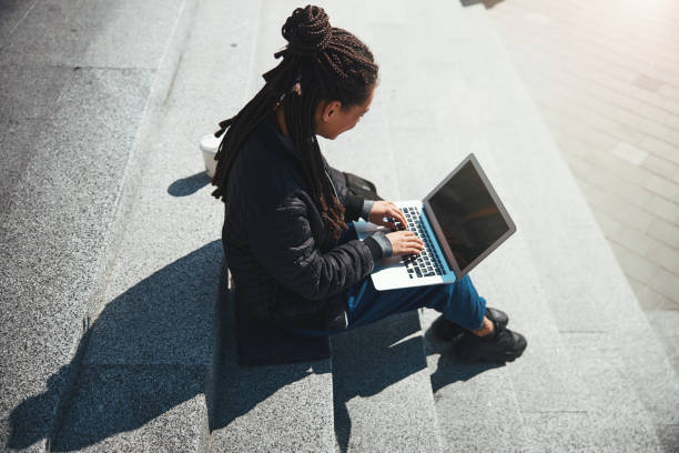 istock Woman with cornrows typing an email message on her gadget 1329366211