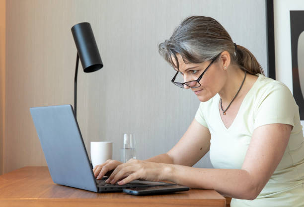 istock middle aged woman working at home 1329366273