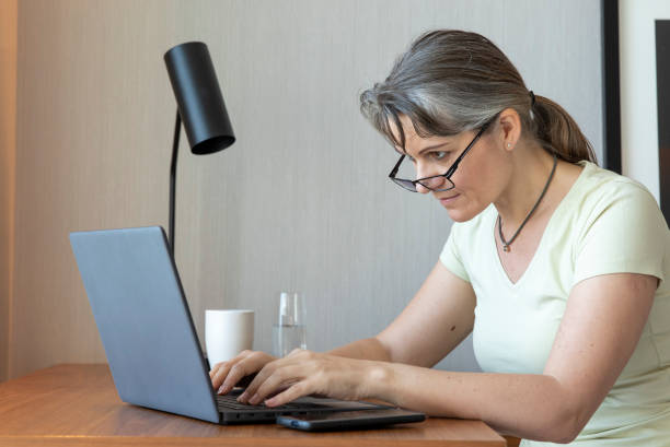 istock middle aged woman working at home 1329366276
