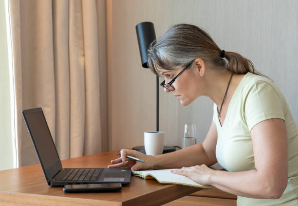 istock middle aged woman working at home 1329366319