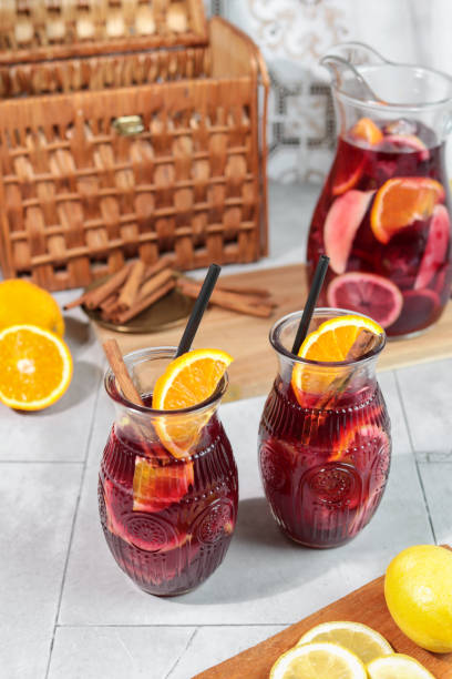 Fresh Sangria summer cocktail drink with Oranges Lemon and Apples on ice in pitcher Fresh Sangria summer cocktail drink with Oranges Lemon and Apples on ice in pitcher sangria stock pictures, royalty-free photos & images