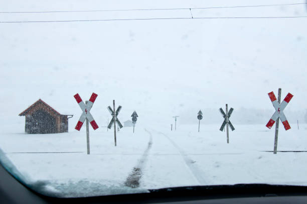 jazda na otwartym przejeździe kolejowym w obfitych opadach śniegu i mgle - drivers point of view country road snowing blizzard zdjęcia i obrazy z banku zdjęć