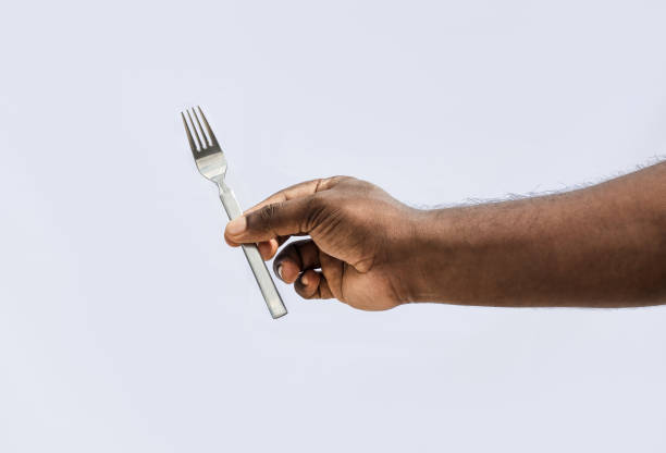 istock A male holding a fork with two fingers on isolated white background 1329380323