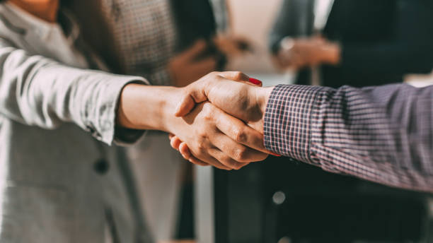 close up. young casual business people shaking hands with each - hand shake imagens e fotografias de stock