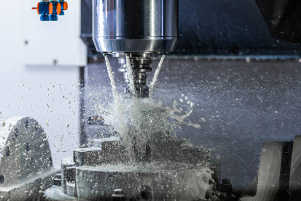 istock a process of industrial wet milling in 5-axis cnc machine with coolant flow under pressure and freezed splashes 1329383375