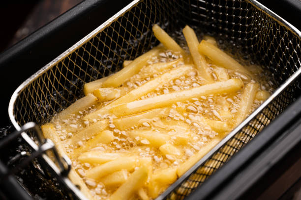 friing potatos in fryier für pommes frites - kartoffel grundnahrungsmittel stock-fotos und bilder