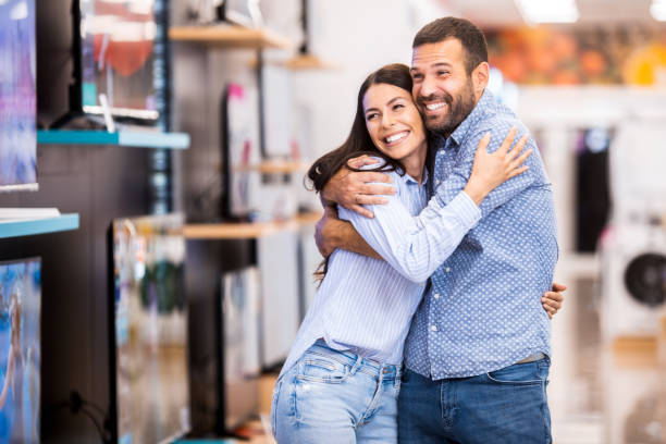 счастливая пара наслаждается покупками для своего нового дома - sale relationships loving indoors стоковые фото и изображения