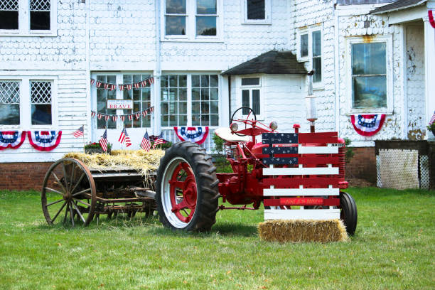 Antique farm Tractor with grain drill machine decorated with US flag to celebrate Independence Day at Snyder's Farm, Somerset, NJ on July 4.2021.