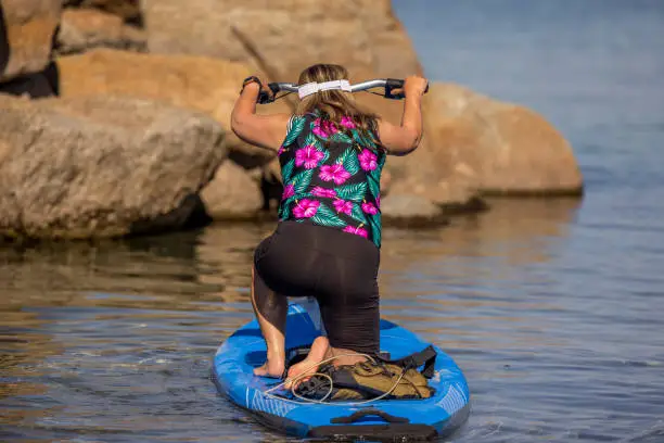 High quality stock photos of two women paddle boarding on a lake.