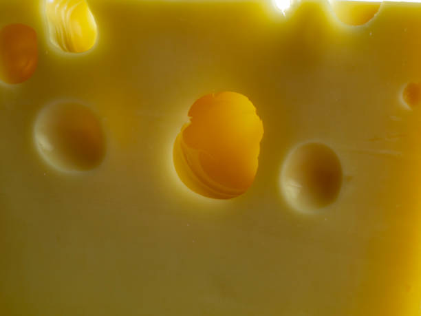 istock Cheese background with holes, full frame. Emmental Swiss cheese, close-up. 1329393343
