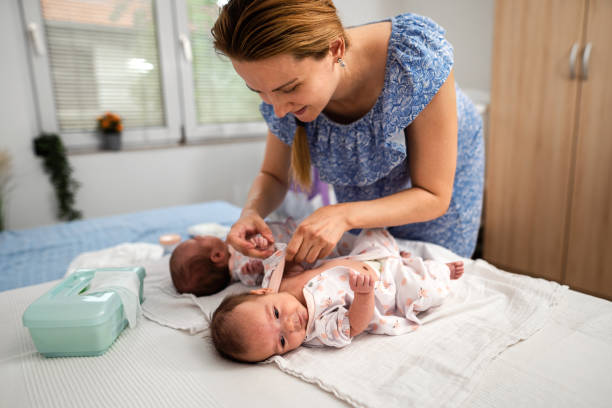 istock Mother changing twin babies clothes at home 1329393408