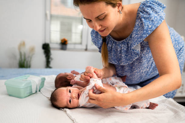 istock Mother changing twin babies clothes at home 1329393451