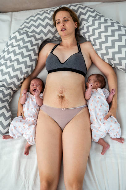 그녀의 아기와 임신에서 그녀의 복부에 스트레치 마크를 가진 어머니 - baby eating child mother 뉴스 사진 이미지