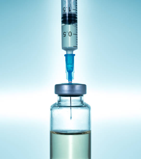 istock Hypodermic syringe needle inserted into a vaccine ampoule or bottle 1329396526