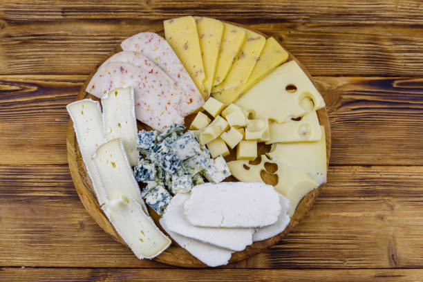 istock Cheese platter with different kinds of cheese on wooden table. Top view 1329397047