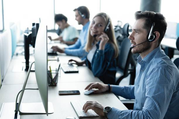 istock Young handsome male customer support phone operator with headset working in call center 1329397345
