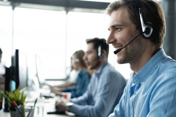 istock Young handsome male customer support phone operator with headset working in call center 1329397349