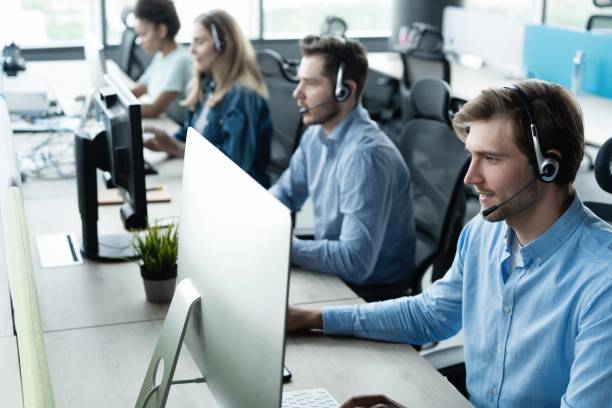 istock Young handsome male customer support phone operator with headset working in call center 1329397356