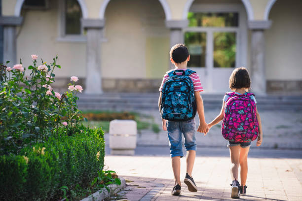 istock Back to school. Happy kids walking with backpacks 1329398147