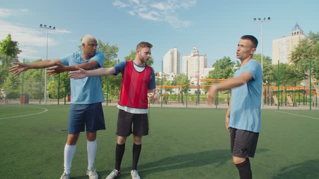 Footballers expressing disagreement, arguing with arbiter on pitch