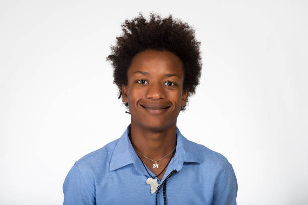 istock Young black boy looking at camera smiling against white background. 1329404151