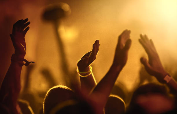 Sea of hands under the yellow stage light