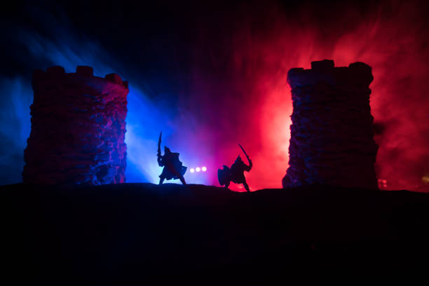 istock Medieval battle scene. Silhouettes of figures as separate objects, fight between warriors at night. Creative artwork decoration. Foggy background. 1329406931
