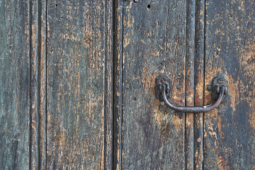 Close up of a rusty lock fitted to a shabby French shutter