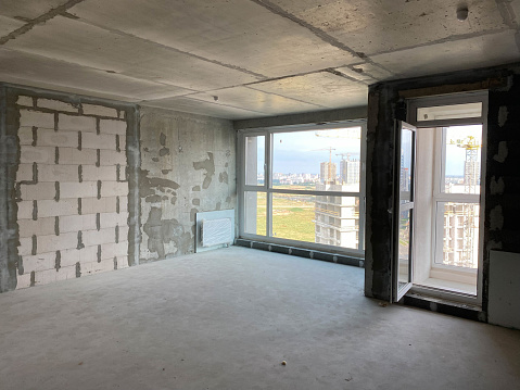 New apartment, new building without finishing and repair, with free planning and walls made of concrete, bricks and gas silicate blocks without partitions and with large panoramic windows.