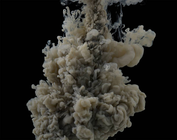 istock explosion in water of dark gray paint, dissolves in clouds in water. Black background. 1329411379
