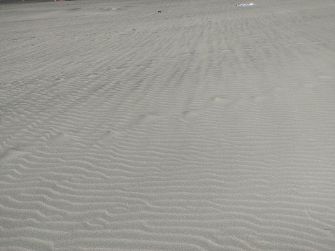 Overhead photo of beach sand forming waves when the wind blows