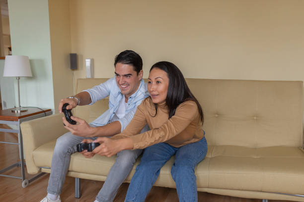 istock Young Woman is Having Fun with her Boyfriend while Playing Computer Games at Home. 1329415299