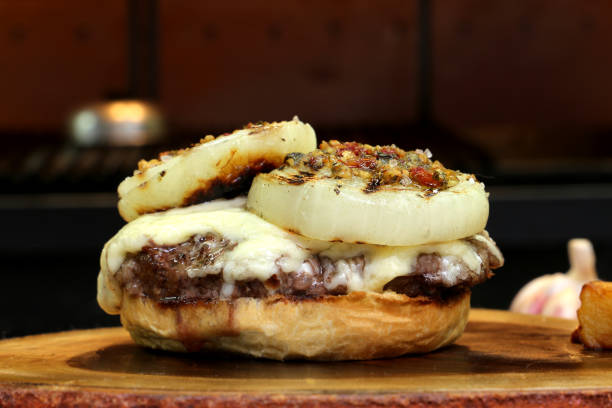 istock Burger with onion on top and Chimichurri. On a rustic wooden background 1329418842