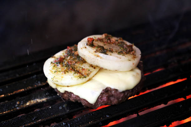 istock Burger with onion on top and Chimichurri. On a bbq 1329419787