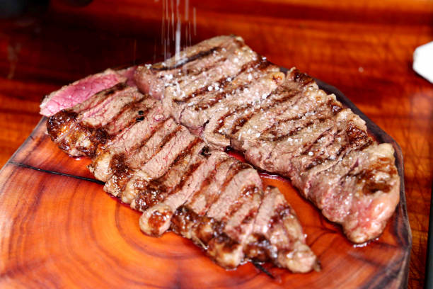 picanha or rump steak. cutting a juicy steak on a wooden board - picanha beef meat rare imagens e fotografias de stock