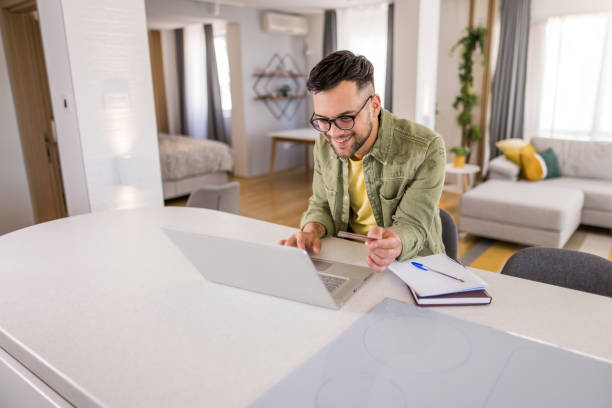 istock Young man using phone and paying online with a credit card. 1329420580